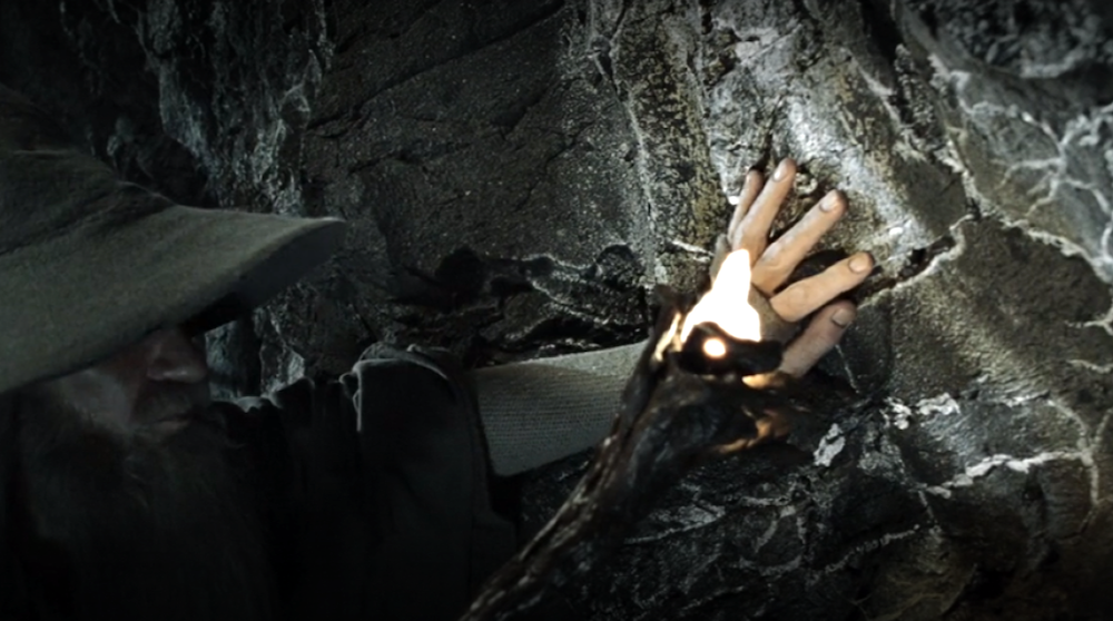 An image of Gandalf using his walking stick to shine light on sparkling bits of mithril ore lining the walls of an abandoned Dwarven mine in Peter Jackson's 'Lord of the Rings' trilogy.